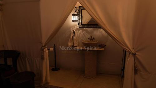 a room with a tent with a sink in it at Merzouga Spirit Luxury Camp in Merzouga
