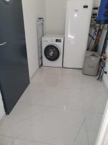 une buanderie avec une machine à laver et un lave-linge dans l'établissement Ideal 24h Le Mans and horse European pole, à Savigné-lʼÉvêque