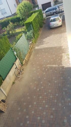 a bike parked on a brick sidewalk next to a car at family in Schiltigheim
