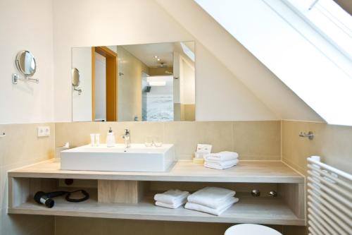 a bathroom with a sink and a mirror at Boutiquehotel Myn Utspann in Husum