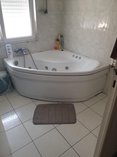 a white bath tub in a bathroom with a window at family in Schiltigheim