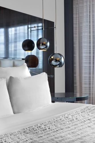 a bedroom with a bed and a glass table at Le Méridien Paris Arc De Triomphe in Paris