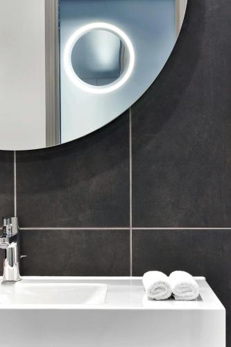 a bathroom with a sink and a mirror at Le Méridien Paris Arc De Triomphe in Paris