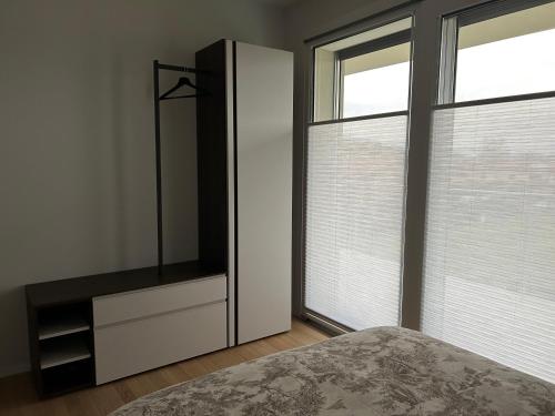 a bedroom with a bed and a dresser and two windows at ALBENZA GREEN VILLAGE bed and breakfast in Almenno San Bartolomeo