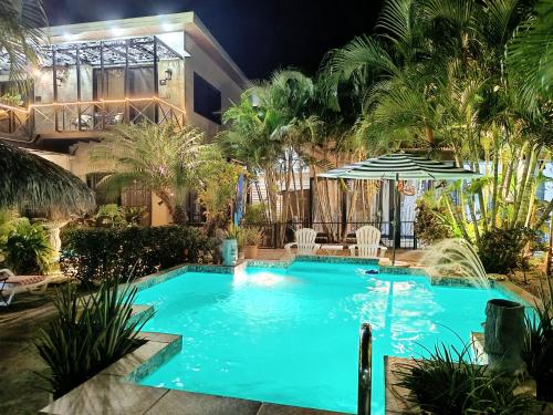 a swimming pool in front of a house at night at Suite Paraiso Azul in Tamarindo