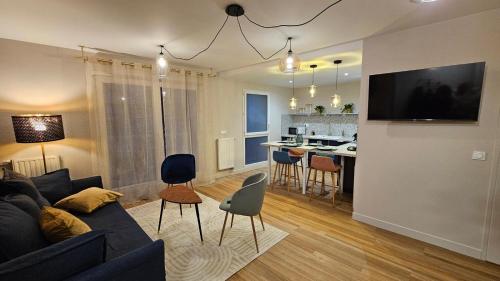 un salon avec un canapé et une cuisine dans l'établissement L'Écrin Bleu, à Aubervilliers