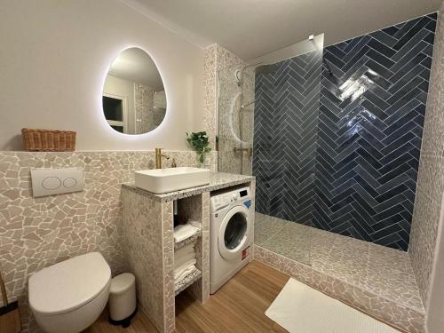 une salle de bain avec un lavabo et une machine à laver dans l'établissement L'Écrin Bleu, à Aubervilliers