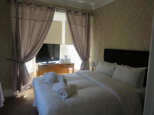 a bedroom with a large white bed with towels on it at The Queens Arms Hotel Acomb in Acomb