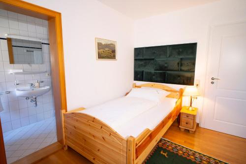 a bedroom with a bed and a bathroom with a sink at NATURION Hotel Hinterzarten in Hinterzarten