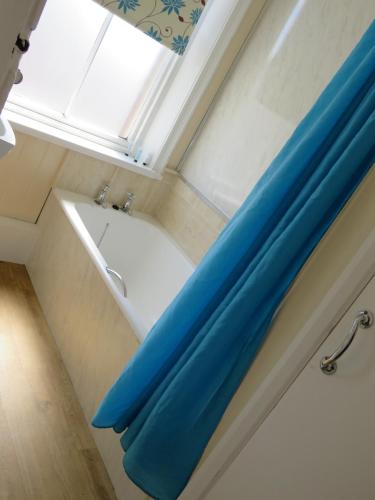 a bathroom with a bath tub and a window at The Queens Arms Hotel Acomb in Acomb