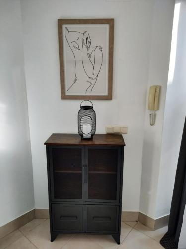 a black dresser with a clock on top of it at Côté Baie avec parking-wifi- draps et serviettes in Hendaye