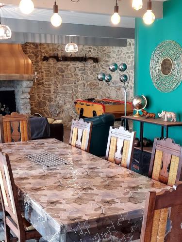 a dining room with a table and a green wall at Maison de village au pied des Pyrénées in Marignac