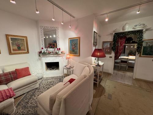 a living room with white furniture and a fireplace at Rana B&B in Ornago