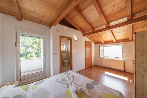 a bedroom with a bed and a wooden ceiling at Apartment Sea Sponge in Brodarica