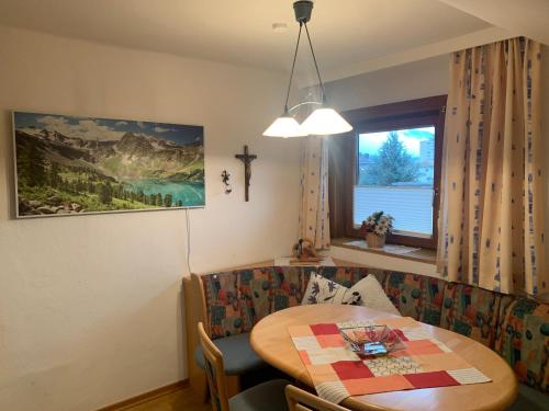 a dining room with a table and a cross on the wall at Ferienwohnung Sonnwendhof "Inntalblick" im Dachgeschoss in Schwaz