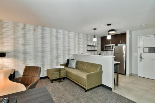 a living room with a couch and a kitchen at Residence Inn by Marriott Eau Claire in Eau Claire