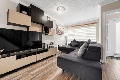 a living room with a large flat screen tv at Stylish 3-Bed Close to MCR City Centre for 8 Guests in Manchester