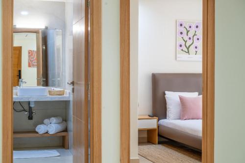 a bathroom with a sink and a bed and a mirror at Charming Cozy apartments with terrace, Haut Agdal in Rabat