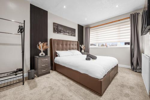 a bedroom with a large bed and a window at Stylish 3-Bed Close to MCR City Centre for 8 Guests in Manchester