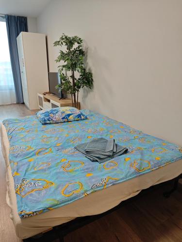 a bed with a blue comforter on top of it at Comfort flat with great location in Prague