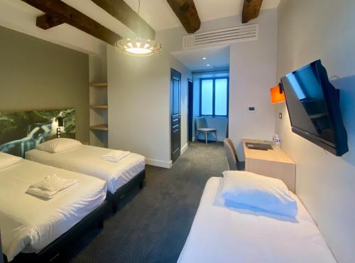 Giường trong phòng chung tại Hôtel Saint-Roch, Saint-Ybard