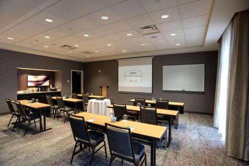 a conference room with tables and chairs and a screen at Courtyard by Marriott Columbus OSU in Columbus
