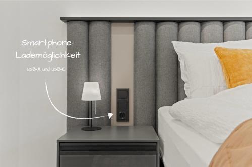a bedroom with a bed and a table with a lamp at 1-2 Personen - Parkplatz - Fahrradgarage - Zentrum - Küche - Balkon - Klima in Sankt Martin