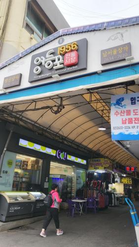 a woman walking in front of a store at Cozy spacious house in Seoul