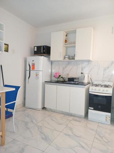 Una cocina blanca con gabinetes y electrodomésticos blancos. en Lo de Pedro Tandil, en Tandil
