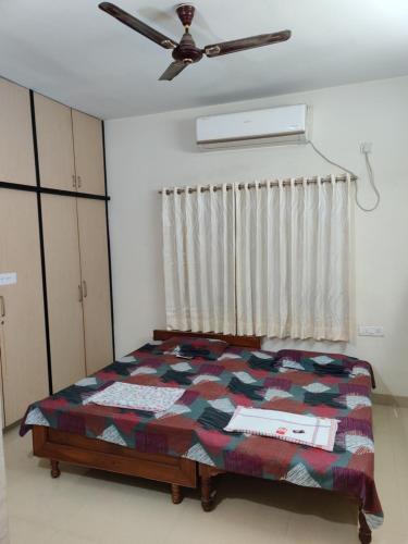 a bedroom with a bed and a ceiling fan at Place away from home in Hyderabad
