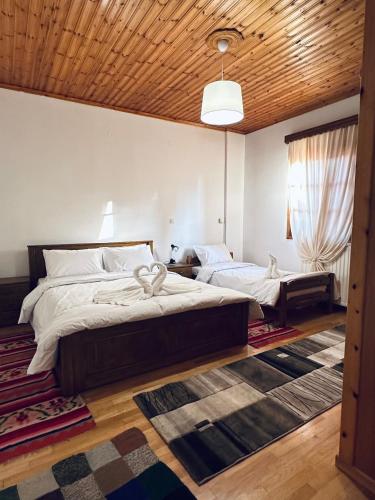 a bedroom with two beds and a wooden ceiling at Koutsogiannopoulos House in Kalavrita