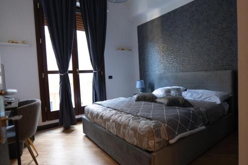 a bedroom with a bed and a large window at V&V art & rooms in Nocera Inferiore