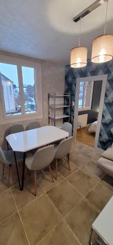 a dining room with a white table and chairs at S-e-r-a-l-y 1 in Égliseneuve-dʼEntraigues