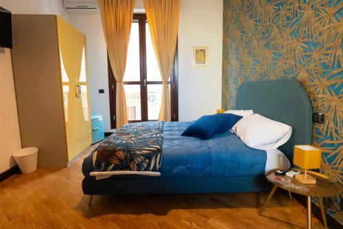 a bedroom with a bed with a blue comforter at V&V art & rooms in Nocera Inferiore