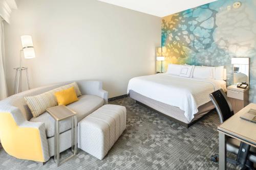 a hotel room with a bed and a couch at Courtyard by Marriott Bryan College Station in College Station
