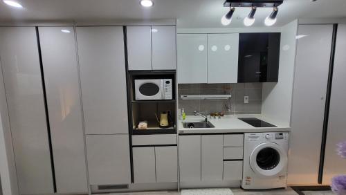 a kitchen with white cabinets and a washing machine at Cozy spacious house in Seoul