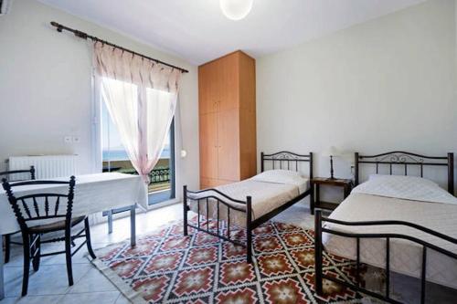 Un dormitorio con dos camas y una ventana y una alfombra. en Penthhouse Studio next to the beach, en Suda