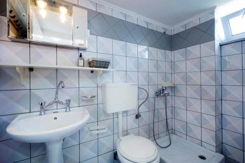 Un baño blanco con inodoro y lavabo. en Penthhouse Studio next to the beach, en Suda