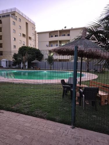 una recinzione con tavolo da picnic e ombrellone di Appartement Caraïbe a Rufisque