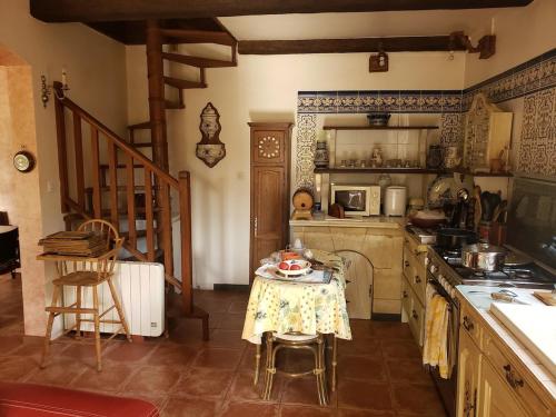 une cuisine avec une table et une cuisinière four supérieur dans l'établissement Maison familiale de charme avec piscine 6-8 personnes, à Laurens