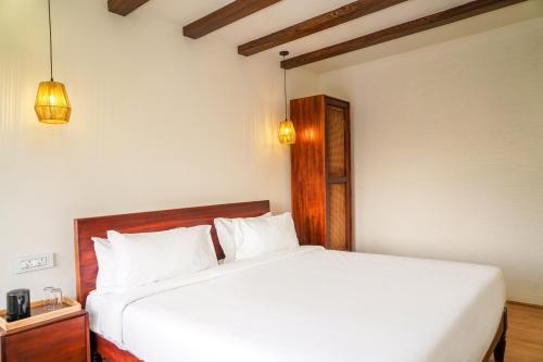 a bedroom with a large white bed in a room at Virgin Valley Leisure Resort in Ooty