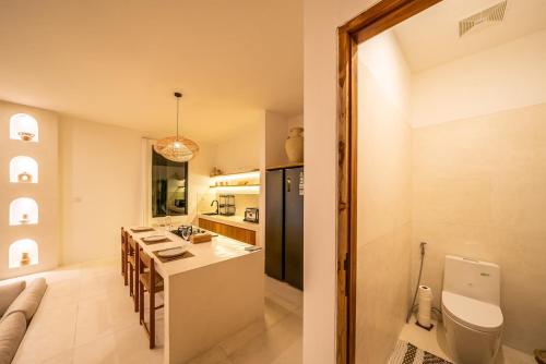 a kitchen and living room with a table and a couch at Villa Somnia Bliss Private One Bedroom Retreat in Tumbak Bayuh