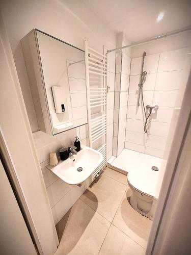 a bathroom with a sink and a shower and a toilet at Liro Apartments Düsseldorf in Düsseldorf