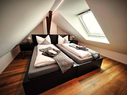 a bedroom with a bed in the attic with a window at Liro Apartments Düsseldorf in Düsseldorf