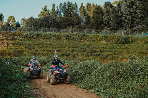 two people riding on atvs on a dirt road at Virgin Valley Leisure Resort in Ooty