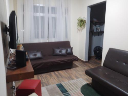 a living room with a couch and a television at Apartamento São Vicente in São Vicente
