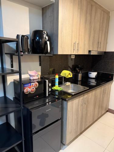 kuchnia ze zlewem i kuchenką mikrofalową w obiekcie 2 bedroom Haven w mieście Manila