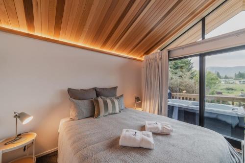 une chambre avec un grand lit avec deux serviettes dessus dans l'établissement Little Nest - Hot tub under the galaxy, à Lac Tekapo