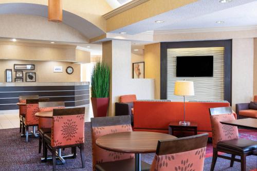 a restaurant with tables and chairs and a flat screen tv at Residence Inn by Marriott Evansville East in Evansville