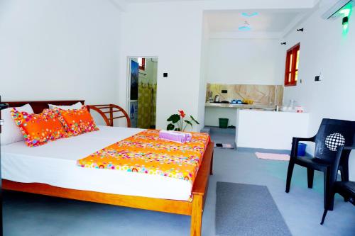 a bedroom with a bed with orange pillows at White rose villa in Weligama